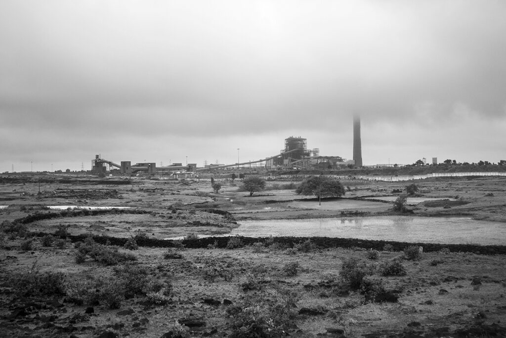 a steel plant surrounded by clouds as seen from a train in easter India
