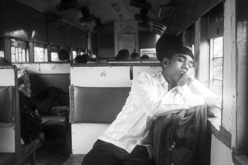 a man sleeping peacefully by the window on a train ride in India